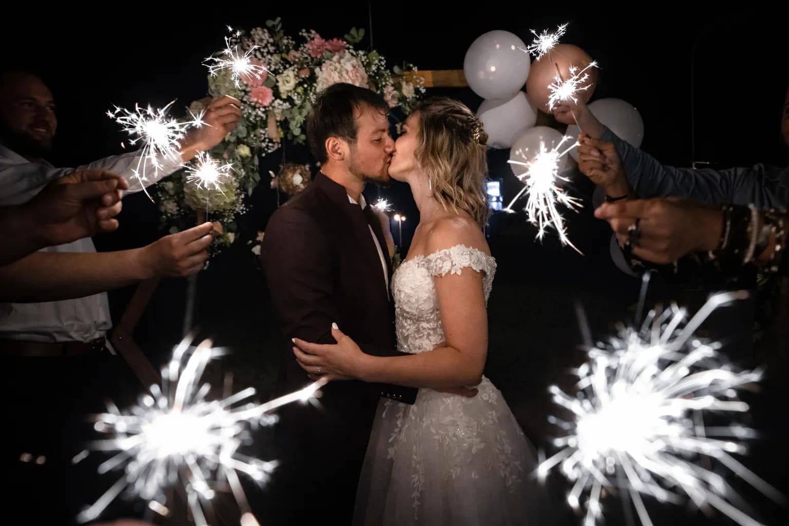 les mariés s'embrassent entourés de bougies magiques dans la nuit