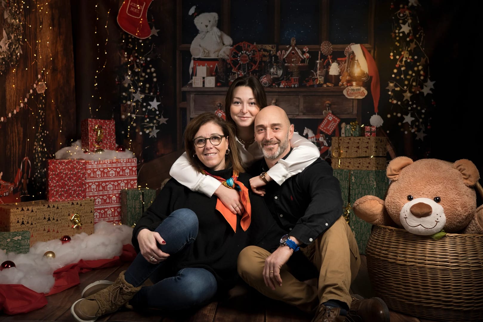 Des parents et leur fille posent dans un décor de Noël