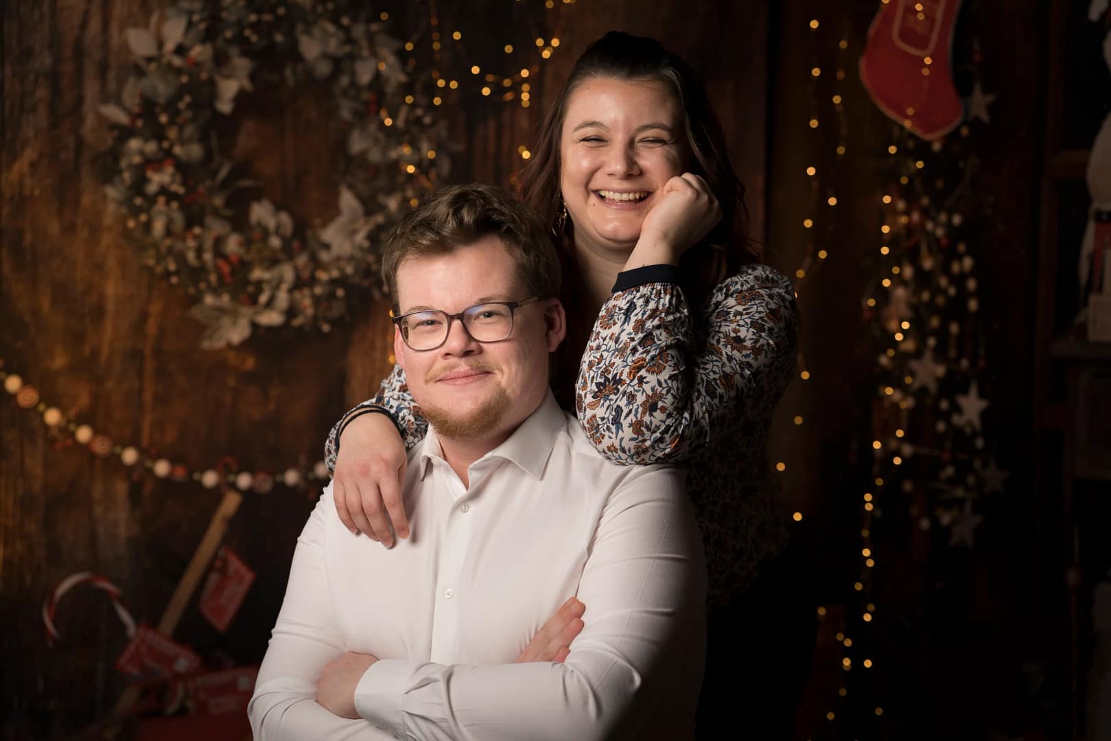 Un frèere et une soeur pose dans un décord de Noël durant une séance photo