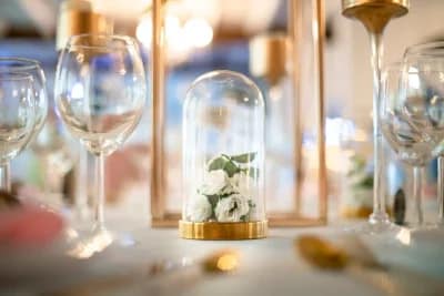 Décoration de table d'un mariage : des fleurs blanches sous une cloche en verre