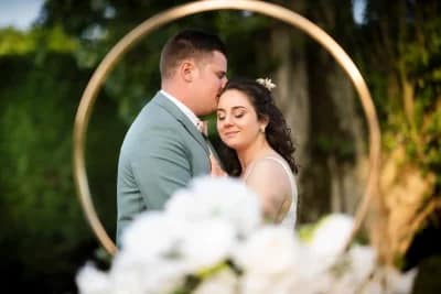 couple de mariés s'enlaçant tendrement et apparaissant à l'intérieur d'une bague de mariage