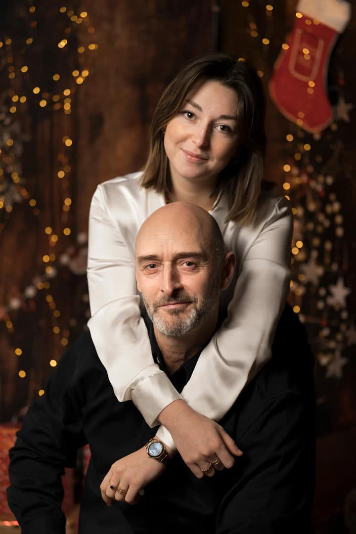 Une jeun fille prends son père dans ses bras pendant un shooting Noël